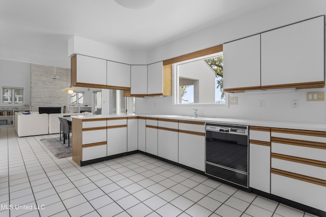 11 Bayou Pl, Gulfport, MS 39503 - kitchen with dishwasher, light countertops, white cabinetry, open floor plan, and a peninsula