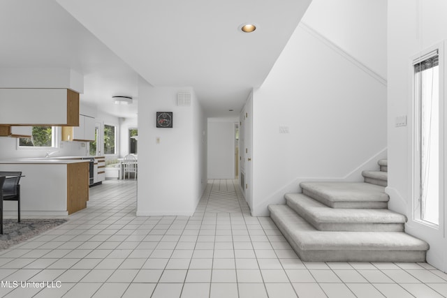 11 Bayou Pl, Gulfport, MS 39503 - hallway featuring stairs, a towering ceiling, recessed lighting, light tile patterned flooring, and baseboards