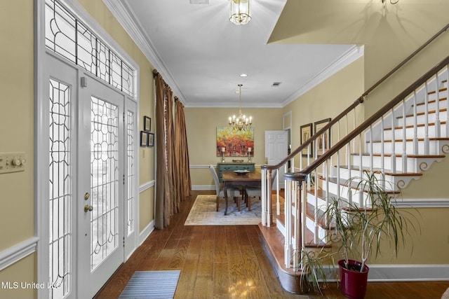 entrance foyer with a notable chandelier, dark hardwood / wood-style flooring, and ornamental molding