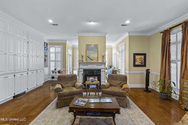 living room featuring a fireplace, wood-type flooring, and crown molding