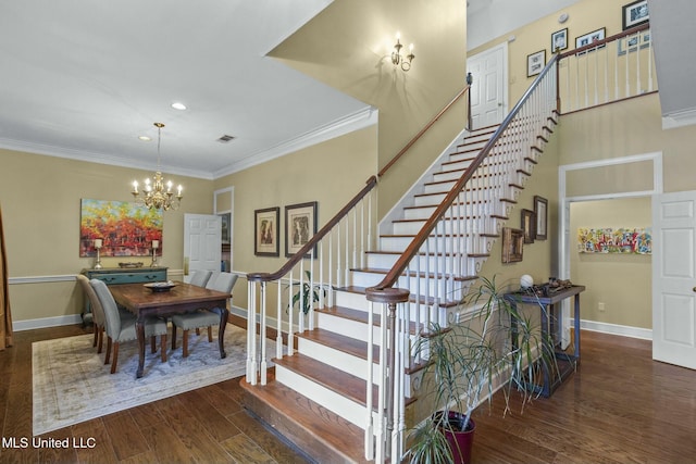 stairway featuring hardwood / wood-style flooring, ornamental molding, and an inviting chandelier