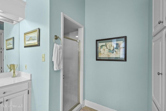 bathroom with vanity and a shower with door