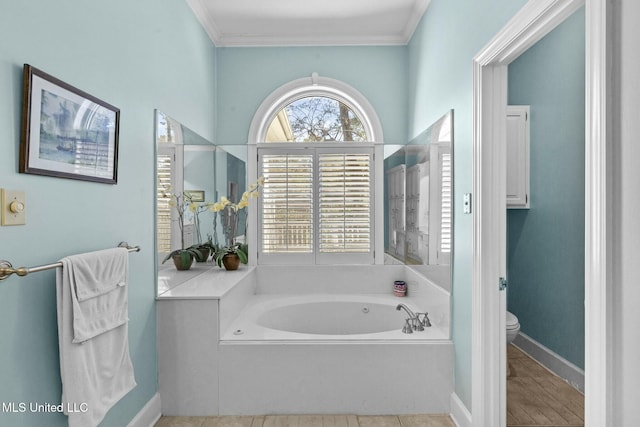 bathroom featuring a washtub, toilet, and crown molding