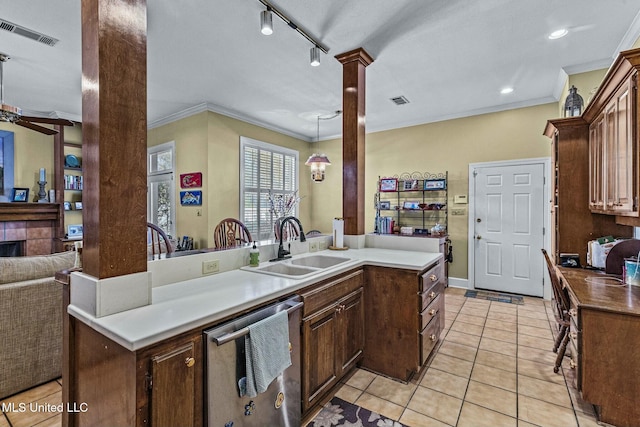 kitchen featuring dishwasher, ornamental molding, an island with sink, and decorative columns