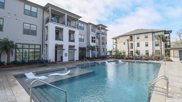 community pool featuring a patio and fence