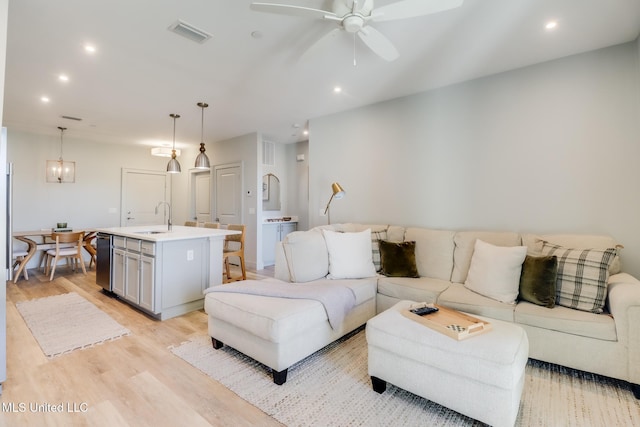 living room featuring light wood-style floors, visible vents, and recessed lighting