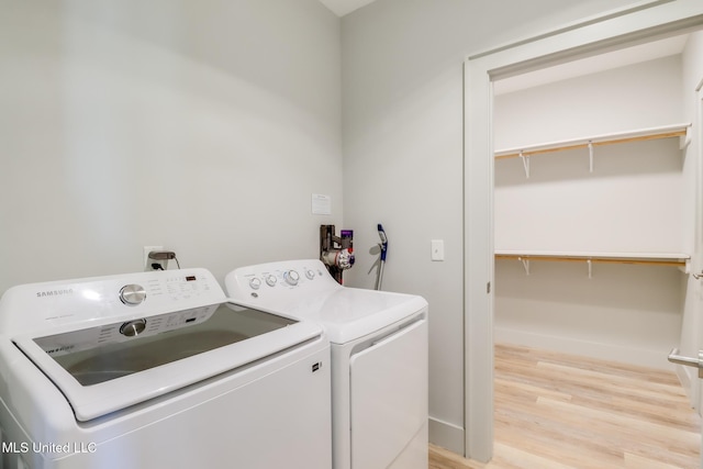 washroom with laundry area, washer and clothes dryer, and light wood-style floors