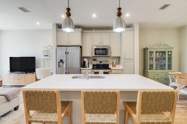 kitchen featuring stainless steel appliances, light countertops, visible vents, and a sink