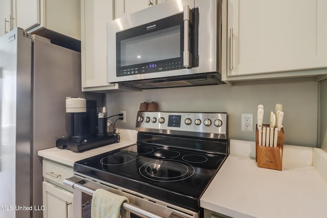 kitchen featuring appliances with stainless steel finishes, light countertops, and white cabinetry