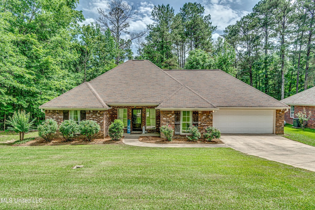 407 Pine Ridge Rd, Florence, MS 39073 - view of front facade featuring driveway, an attached garage, a front lawn, brick siding, and a shingled roof