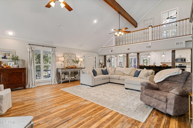 living room with beamed ceiling, light hardwood / wood-style flooring, high vaulted ceiling, and ceiling fan