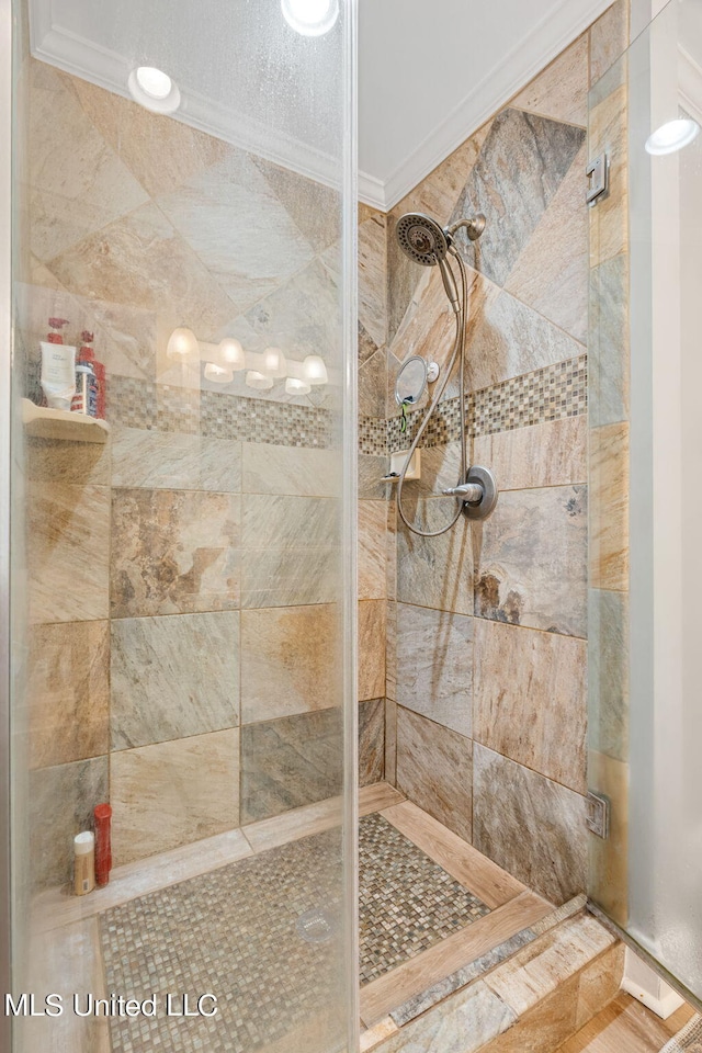 bathroom with ornamental molding and tiled shower