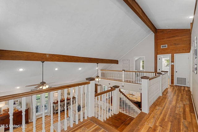 hall with beam ceiling, wood-type flooring, and plenty of natural light