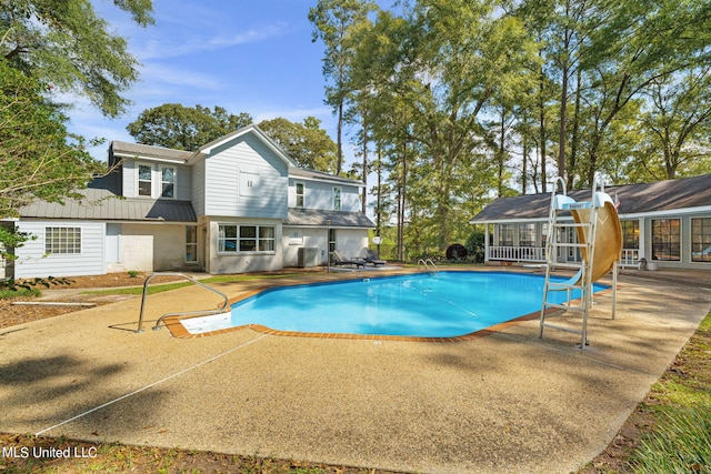 view of pool featuring a water slide and a patio area