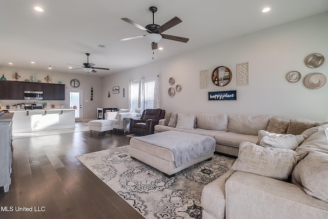 living room featuring ceiling fan and dark hardwood / wood-style flooring