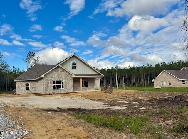 view of home's exterior featuring brick siding, board and batten siding, and an outdoor fire pit