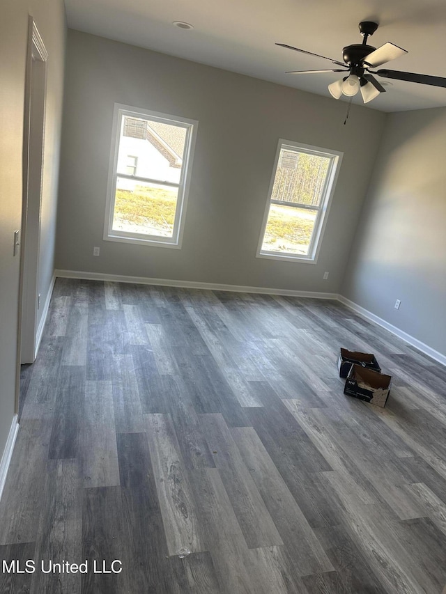 empty room with ceiling fan and dark hardwood / wood-style flooring