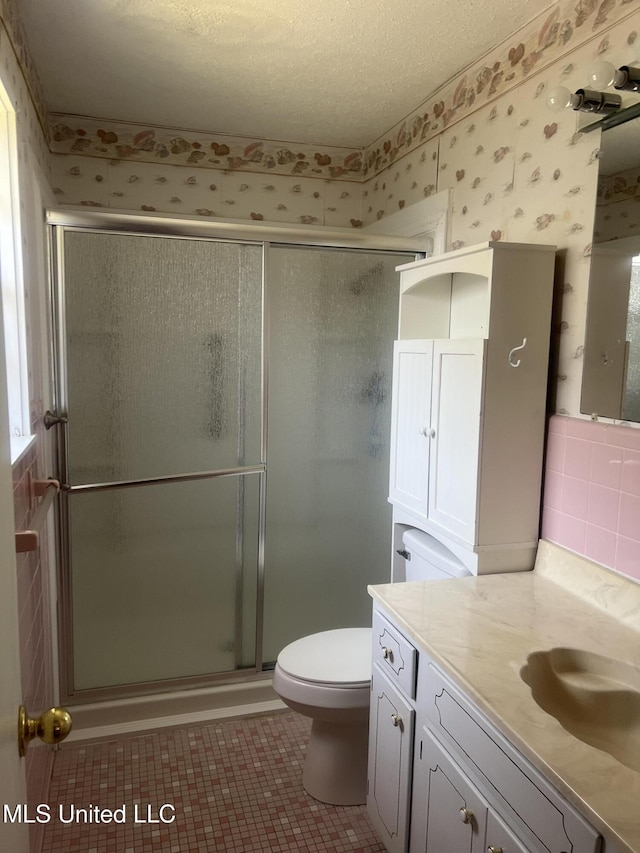 241 Iroquois St, Biloxi, MS 39530 - full bathroom featuring wallpapered walls, vanity, toilet, a stall shower, and tile patterned flooring