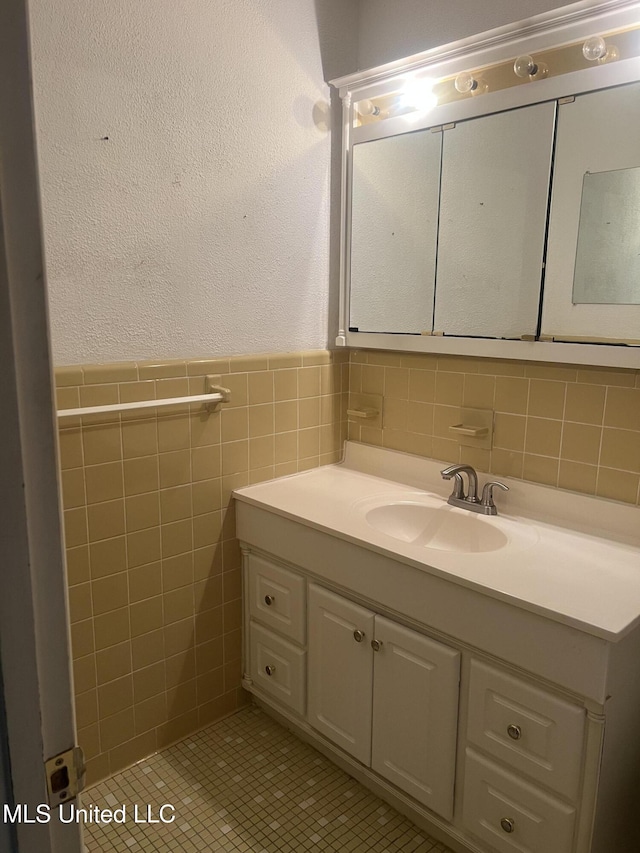 241 Iroquois St, Biloxi, MS 39530 - bathroom featuring vanity, tile walls, a textured wall, wainscoting, and tile patterned flooring
