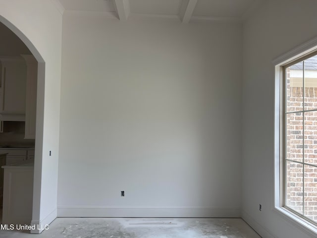 spare room with beamed ceiling and a wealth of natural light