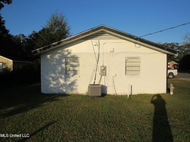 view of property exterior with central AC and a lawn