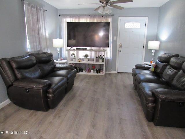 living room with wood-type flooring and ceiling fan