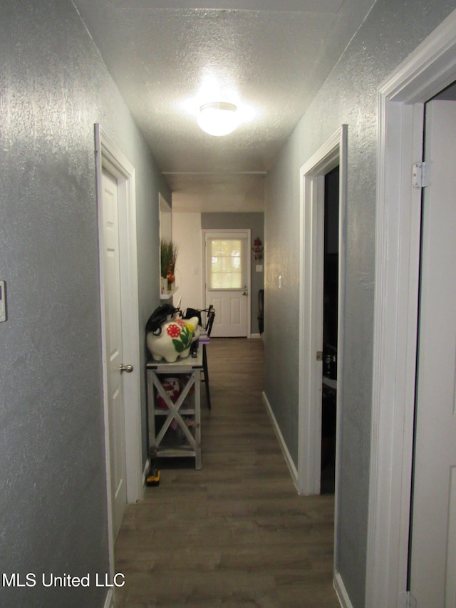 hall with a textured ceiling and dark hardwood / wood-style flooring