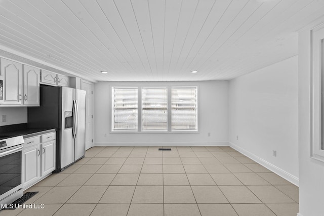 kitchen with appliances with stainless steel finishes, light tile patterned flooring, wooden ceiling, and white cabinetry