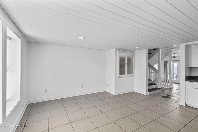 unfurnished living room featuring ceiling fan, light tile patterned floors, and wood ceiling