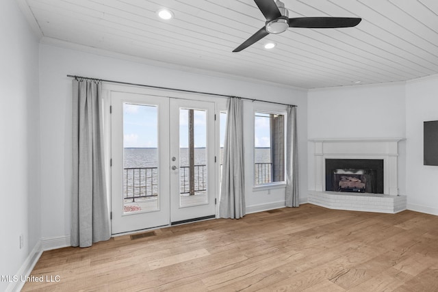 unfurnished living room featuring french doors, wooden ceiling, a fireplace, and light wood-type flooring