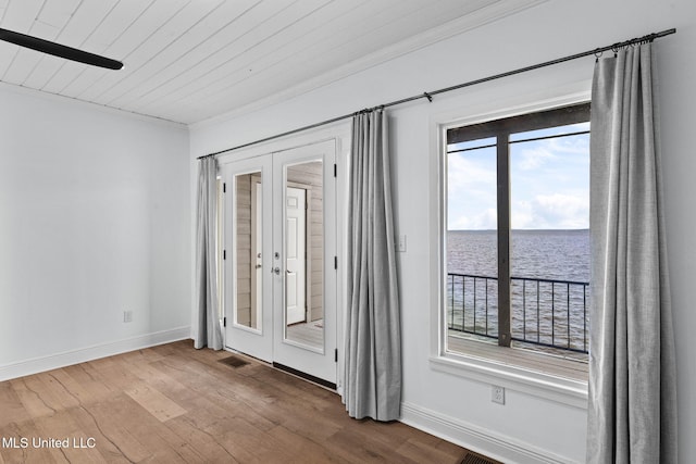 empty room with french doors, wooden ceiling, hardwood / wood-style floors, and a water view