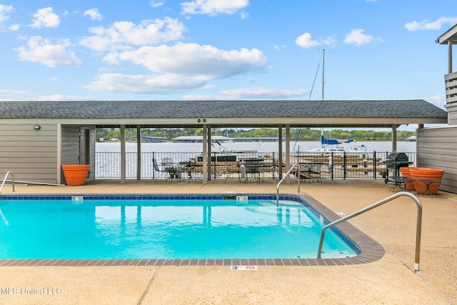 view of pool with a patio area and a water view