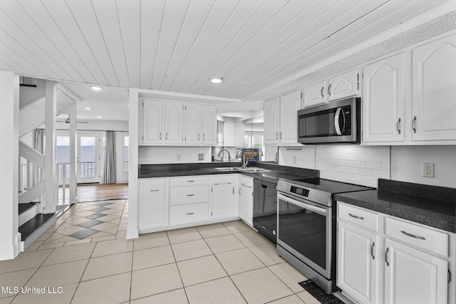 kitchen featuring stainless steel appliances, light tile patterned floors, wood ceiling, decorative backsplash, and white cabinetry