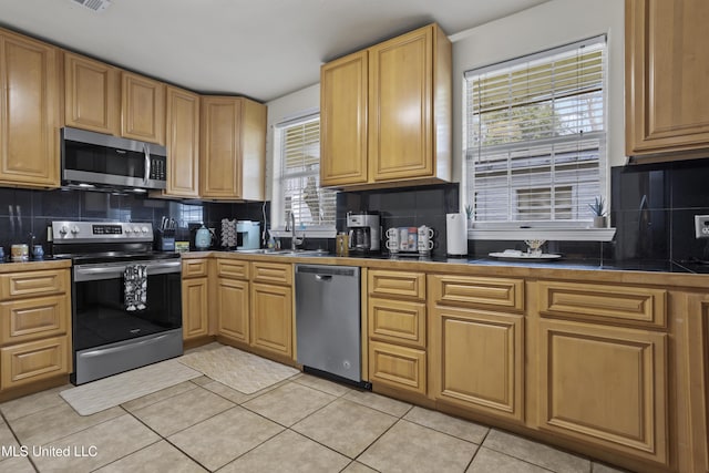 kitchen featuring backsplash, stainless steel appliances, a healthy amount of sunlight, and sink