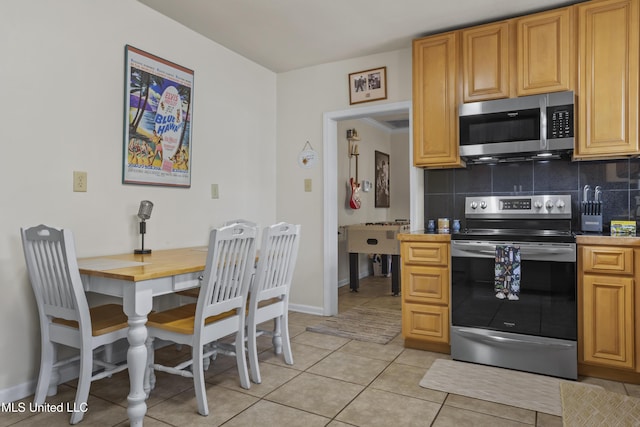 kitchen featuring decorative backsplash, light tile patterned floors, and stainless steel appliances