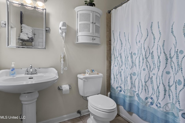 bathroom featuring shower / bath combo with shower curtain, tile patterned flooring, and toilet