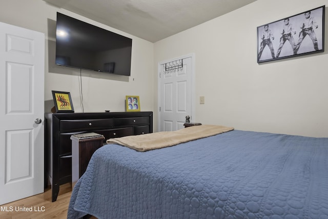 bedroom with wood-type flooring and a textured ceiling