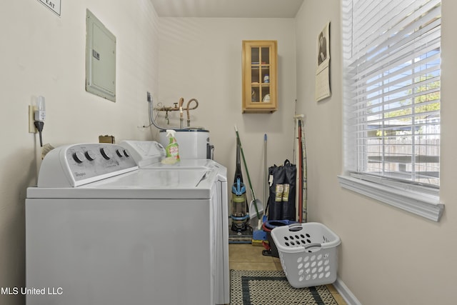 clothes washing area with electric panel, separate washer and dryer, and electric water heater