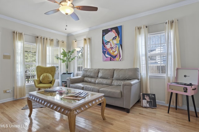 living room with a wealth of natural light, ceiling fan, ornamental molding, and light wood-type flooring