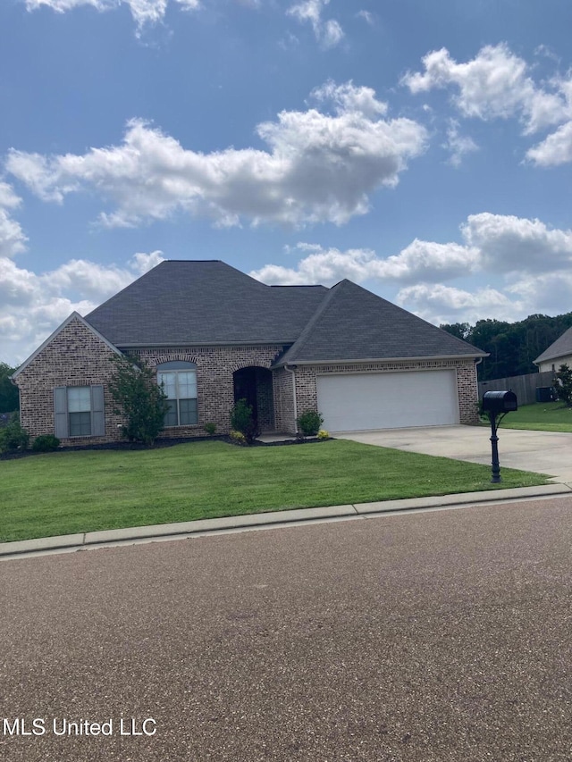 174 Falls Xing, Madison, MS 39110 - view of front facade featuring brick siding, a garage, concrete driveway, a front lawn, and roof with shingles