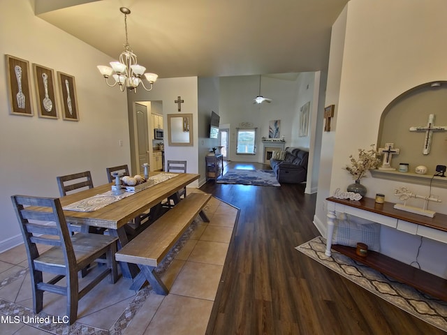 dining area with wood-type flooring, lofted ceiling, and an inviting chandelier