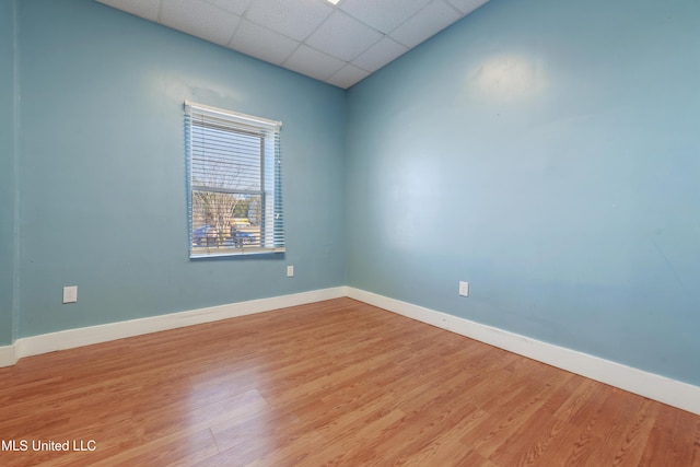 unfurnished room featuring a paneled ceiling and light wood-type flooring