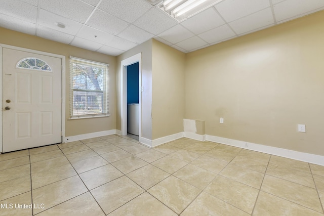 foyer entrance featuring light tile patterned floors and a drop ceiling