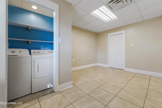 clothes washing area with light tile patterned flooring and washer and dryer