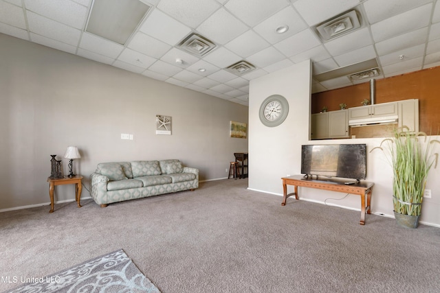 carpeted living room featuring a drop ceiling