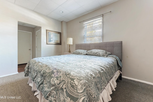 carpeted bedroom with a paneled ceiling