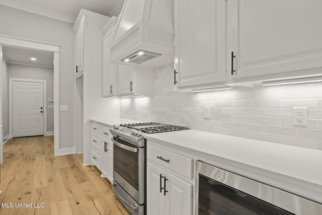 302 Wind Cv, Madison, MS 39110 - kitchen featuring stainless steel gas range oven, premium range hood, beverage cooler, white cabinets, and light countertops