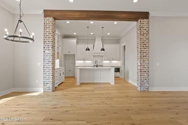 302 Wind Cv, Madison, MS 39110 - kitchen featuring ornamental molding, a sink, premium range hood, a chandelier, and decorative light fixtures