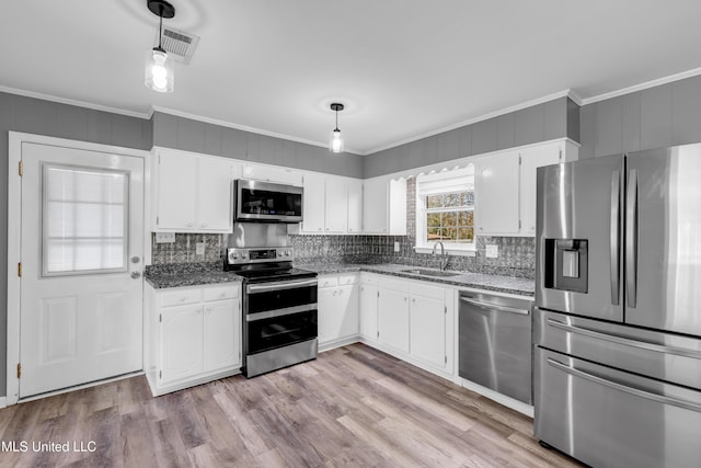 kitchen featuring ornamental molding, appliances with stainless steel finishes, a sink, and visible vents