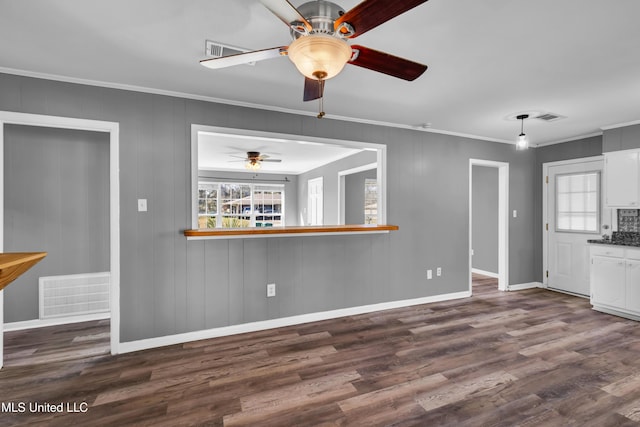 kitchen featuring visible vents, dark wood-type flooring, and ornamental molding